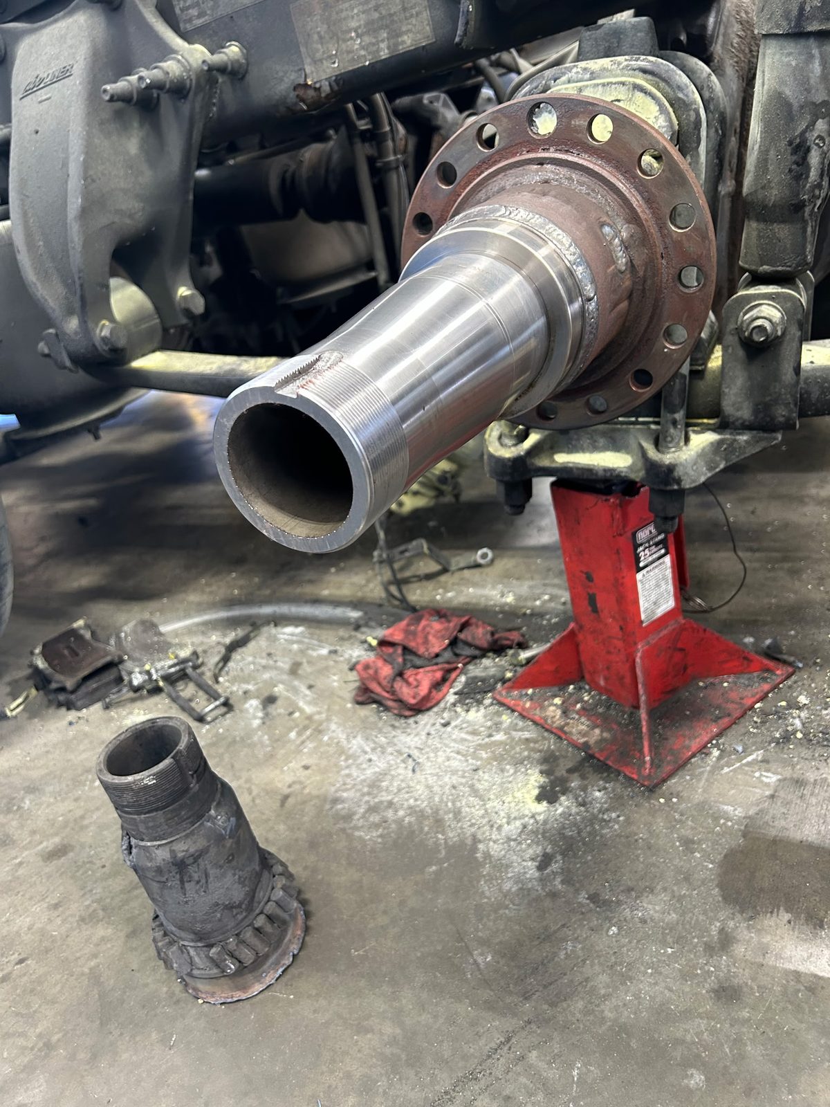 New drive axle spindle installed, with the removed damaged spindle on the ground