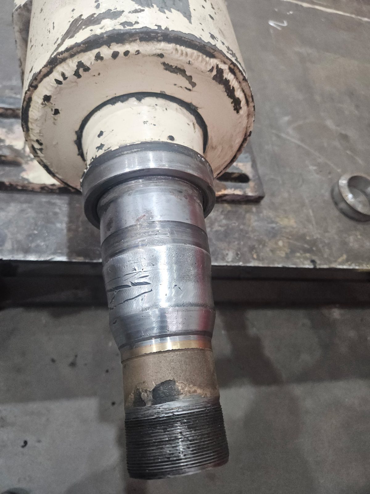 Close-up of the damaged spindle on a paper mill debarking machine roller