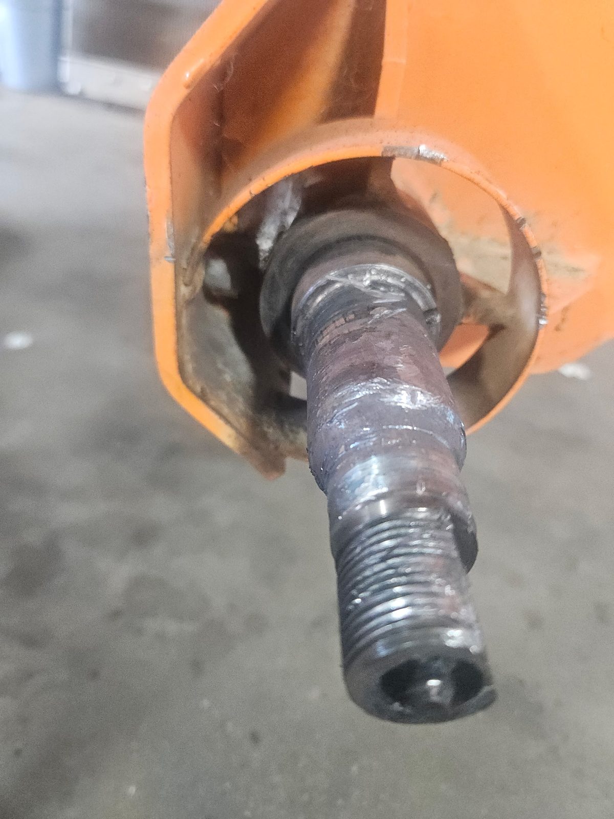 Damaged spindle on a SweepMaster 300 street sweeper before repair