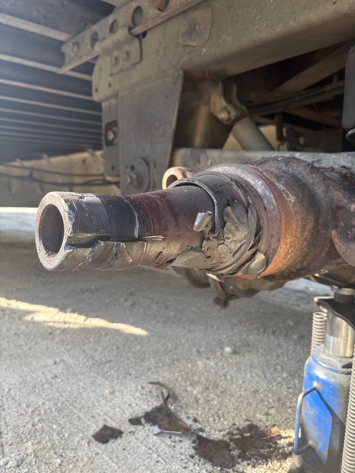 Worn trailer axle spindle and axle end before replacement