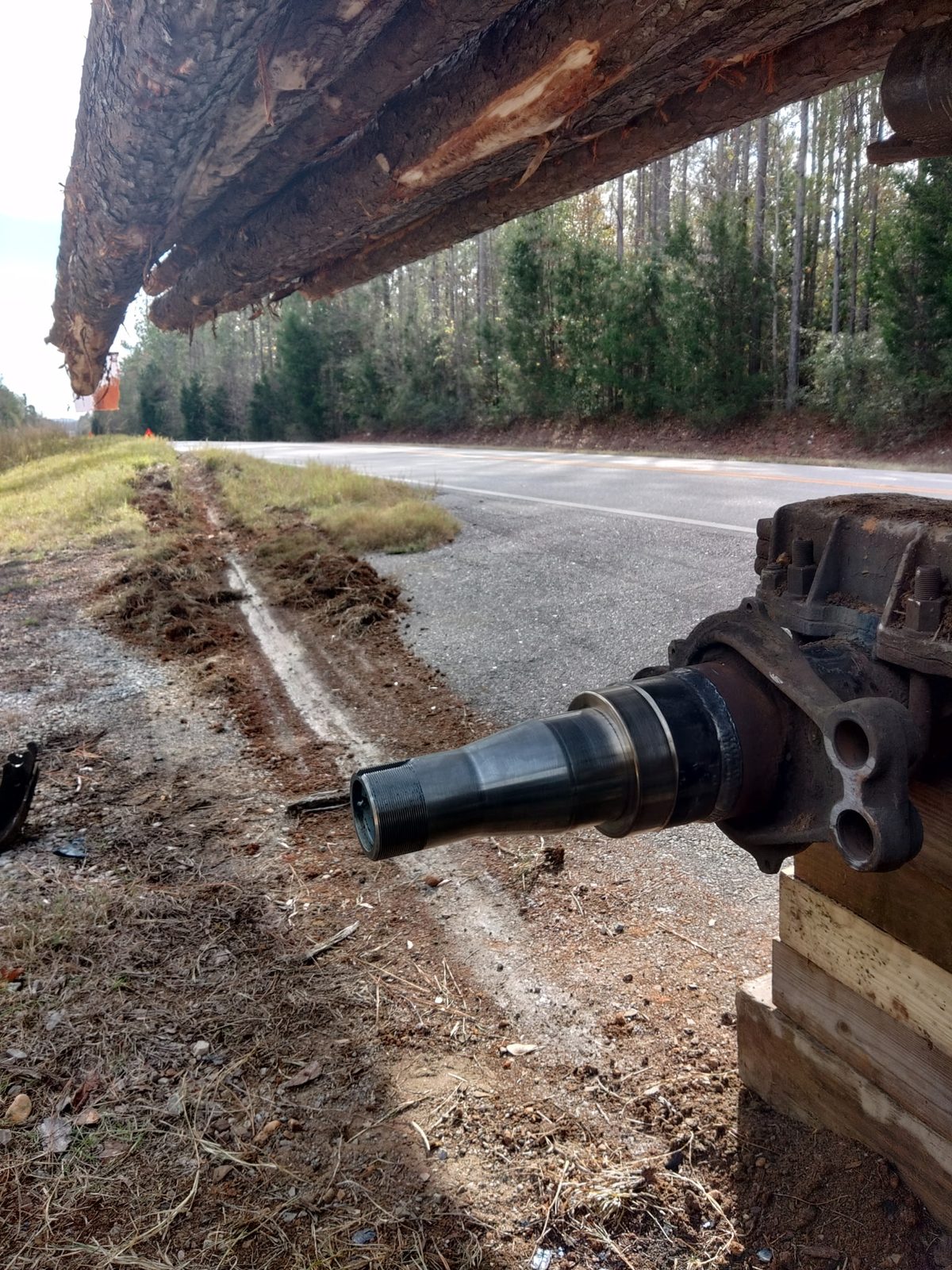 Replacement spindle installed on the logging trailer axle at the roadside